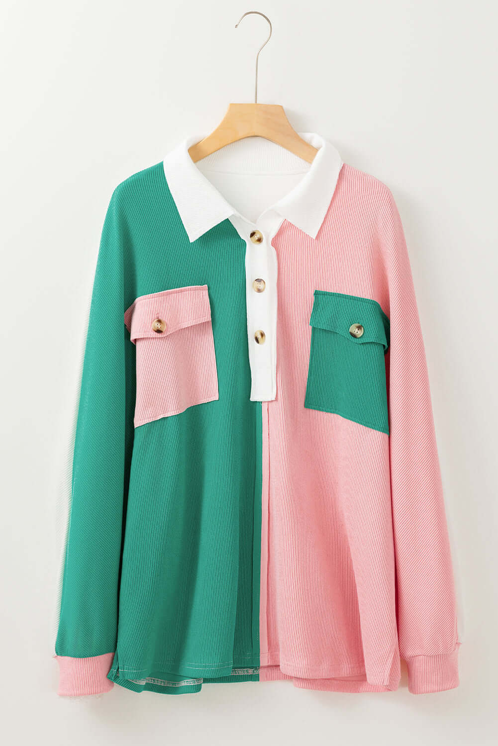 Bold Boundaries Top by Vivian-Lu with buttoned neckline and green-pink color block pattern on hanger.