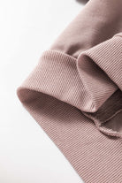 Close-up of beige drop shoulder INNER PEACE sweatshirt fabric showing cozy ribbed cuff and soft material blend.