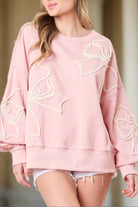 Light pink sweatshirt with off white bow embroidery by Vivian-Lu, casual style, ribbed edges, cozy fit, fashionable for the season.