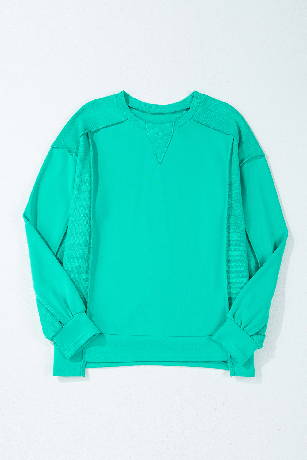 Teal crewneck sweatshirt with splicing details and relaxed fit on a plain background