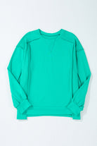 Teal crewneck sweatshirt with splicing details and relaxed fit on a plain background