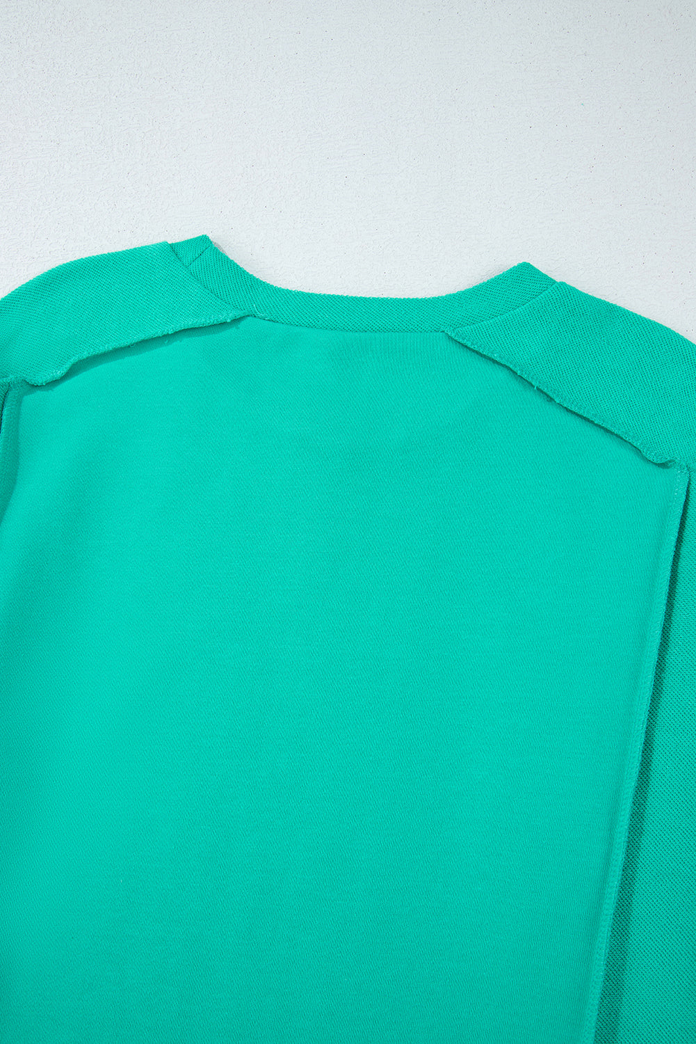 Back view of the teal We Meet Again Crewneck sweatshirt featuring sleek design and splicing details.