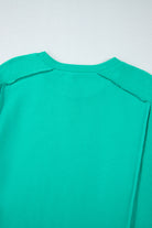 Teal We Meet Again Crewneck back view with splicing details, showcasing round neck and relaxed fit in vibrant teal color.