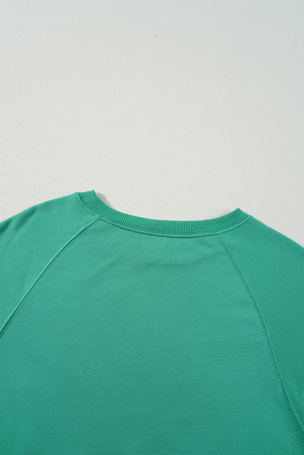 Vibrant aqua Upward Trends top showcasing the classic crewneck and comfortable fit, made from 65% polyester and 35% cotton.