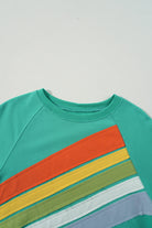 Aqua crew neck top with rainbow color-block and stripes, perfect for casual wear.