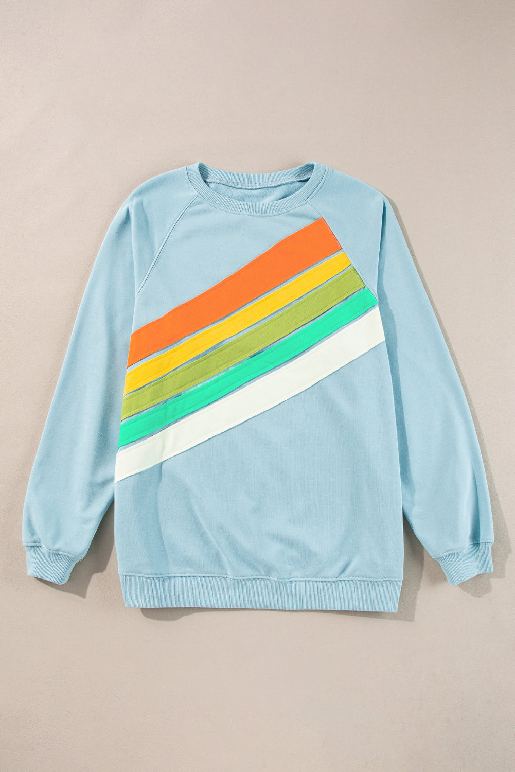 Sky blue pullover with rainbow color-block and stripes, crew neck style, perfect for casual wear.