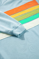 Sky blue crewneck pullover with vibrant rainbow color-block and stripes, made of 65% polyester and 35% cotton.