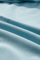 Close-up of sky blue fabric texture, highlighting soft material and vibrant color of the UPWARD TRENDS TOP made of polyester and cotton.