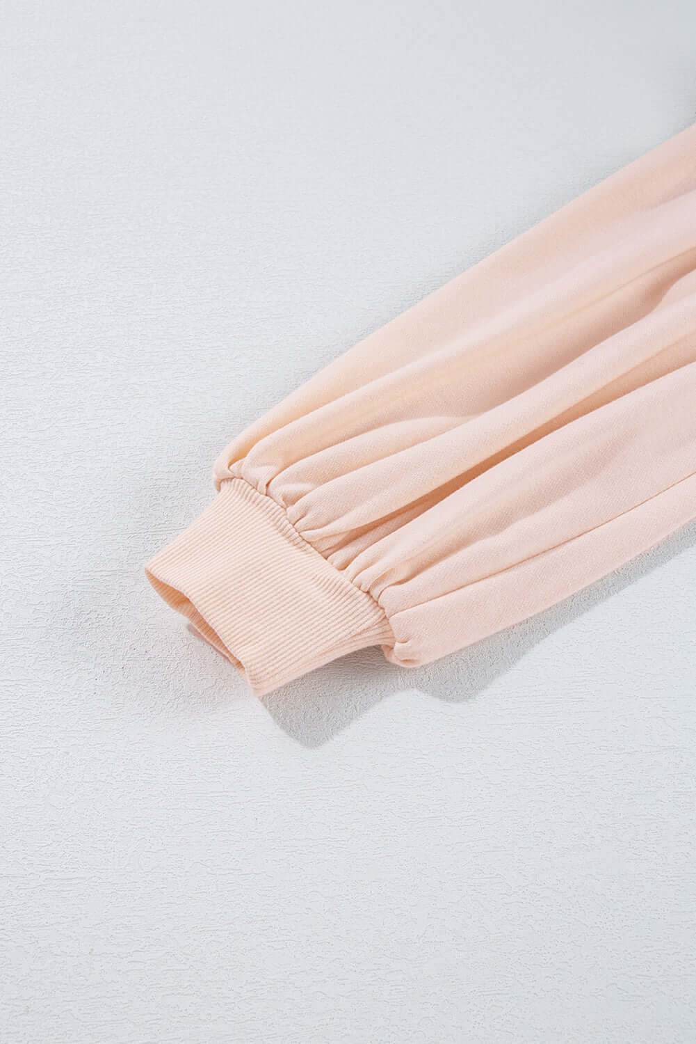 Beige pullover sleeve detail of The Bowtique Top featuring gathered lantern style cuffs.