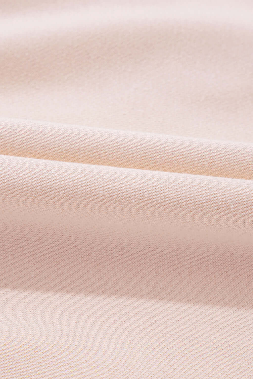 Close-up of soft beige fabric, perfect for The Bowtique Top, showcasing its delicate texture and quality material.