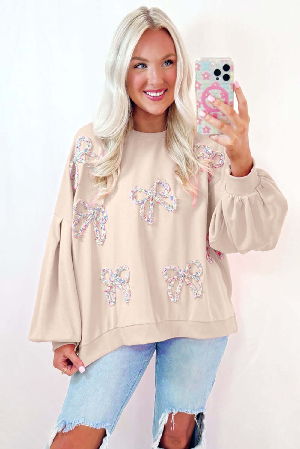 Cute beige Bowtique Top with embroidered bows and lantern sleeves, perfect for a playful, chic look.