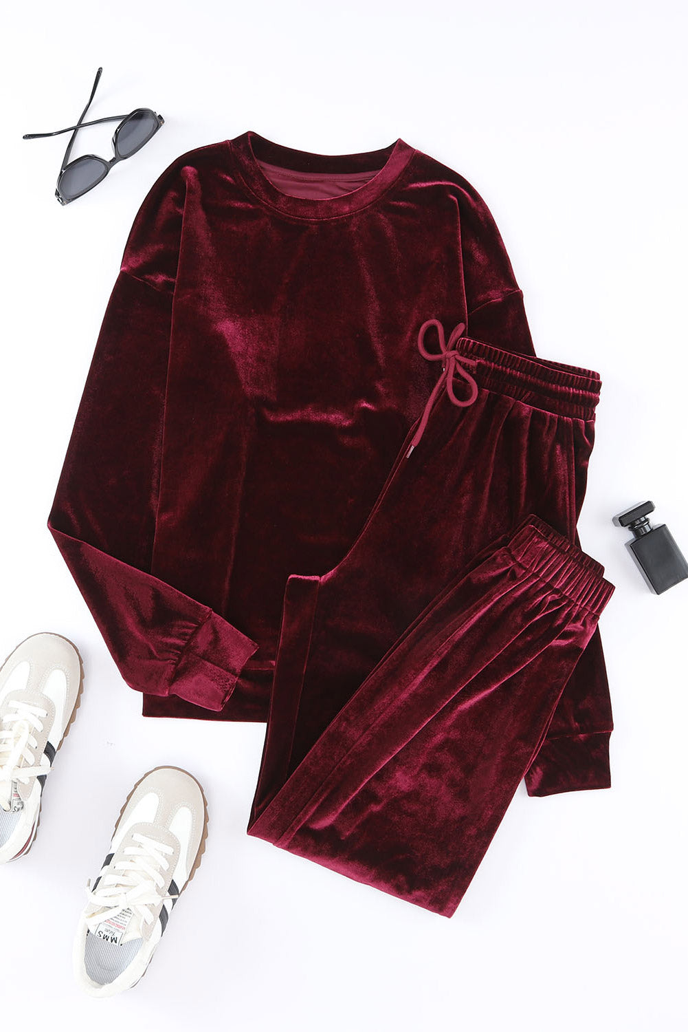 Velvet Wine 2-piece set with long sleeve top and drawstring pants in burgundy, accompanied by sneakers, sunglasses, and perfume.