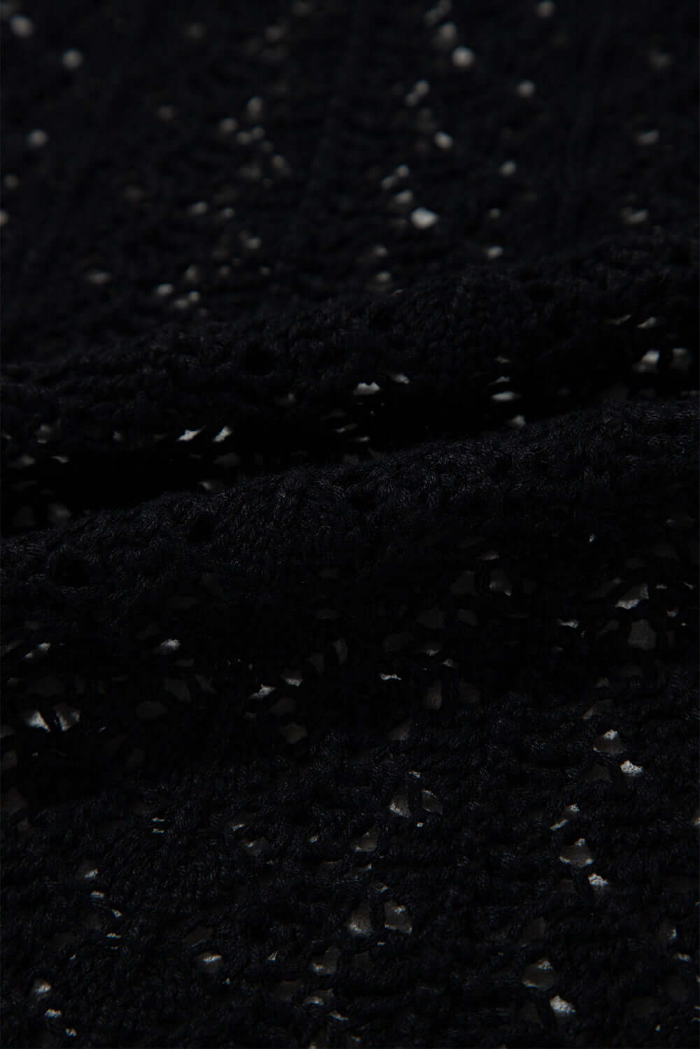 Close-up of black cable knit fabric featuring hollow-out details for the Café Date Cardigan.