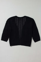 Back view of the Café Date Cardigan in jet black, featuring solid cable knit and chic hollow-out details.
