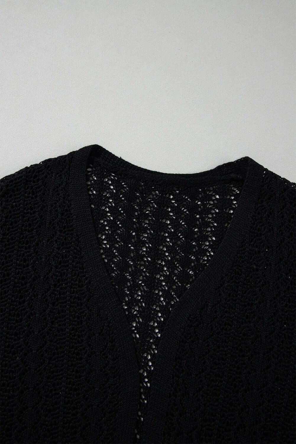 Jet black Café Date Cardigan showing solid cable knit and hollow-out details for a stylish layering essential.