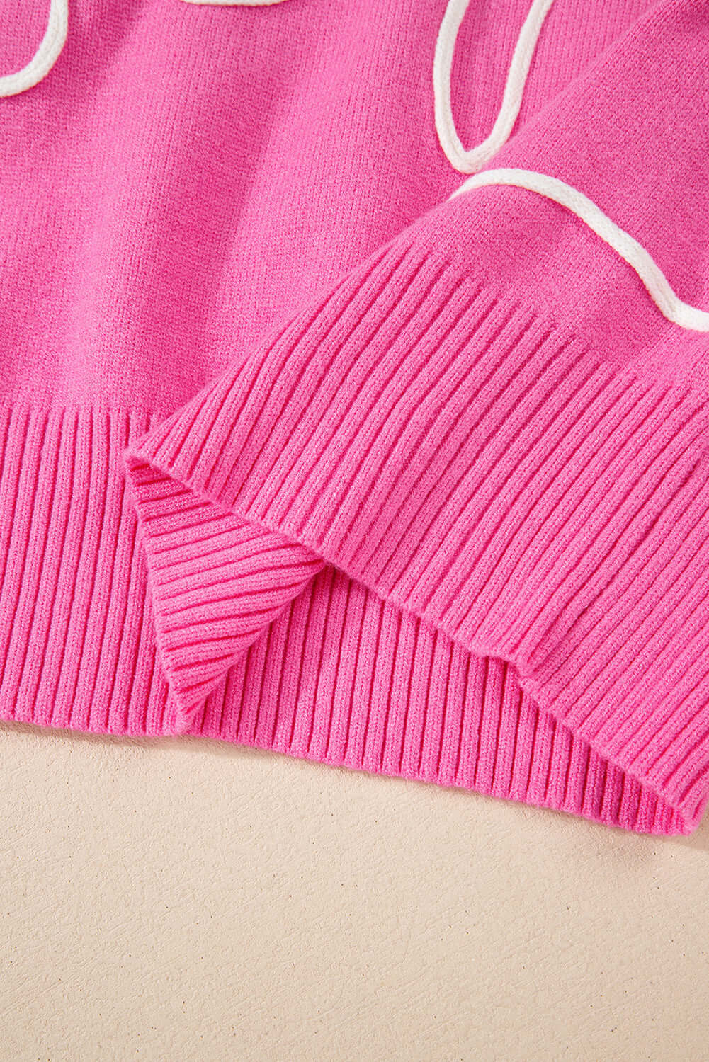 Soft pink sweater with corded bows and ruffled cuff details, showcasing trendy style and comfort for all-season wear.