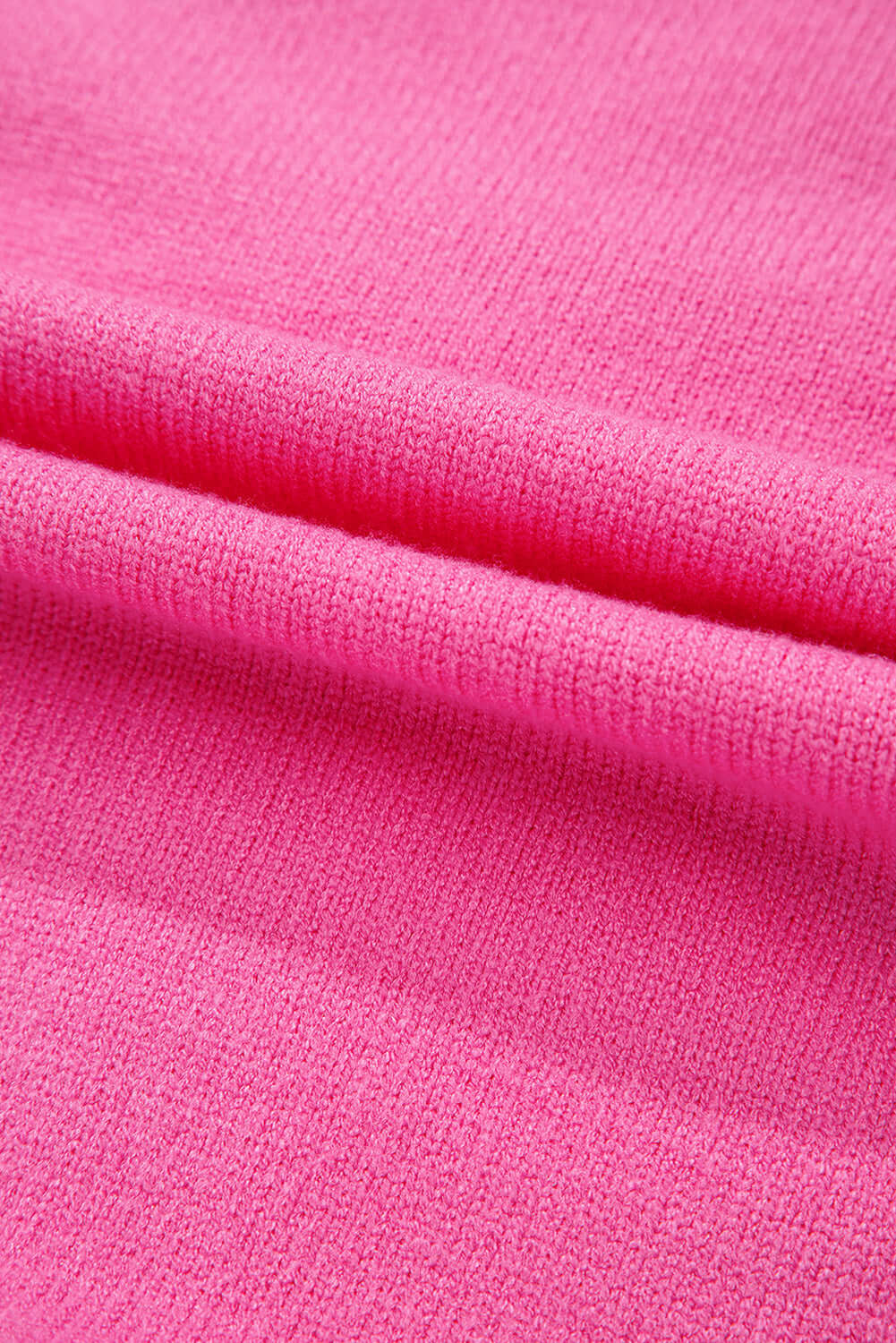 Soft pink sweater fabric close-up showcasing texture and weave.