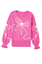 Soft pink sweater with corded bows, dropped shoulders, and ruffled cuffs, perfect for trendy comfort in any season.