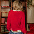 Back view of the MERRY MOMENTS SWEATER in vibrant red with a stylish drop shoulder fit and color block trim.