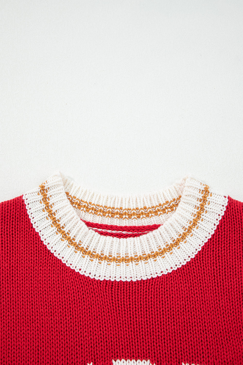 Close-up of the collar on the MERRY MOMENTS SWEATER featuring a vibrant red knit with a decorative gold and white trim.