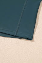 Close-up of the SeaGlass Serve Skort hem showcasing the sea green fabric and fine stitching details.