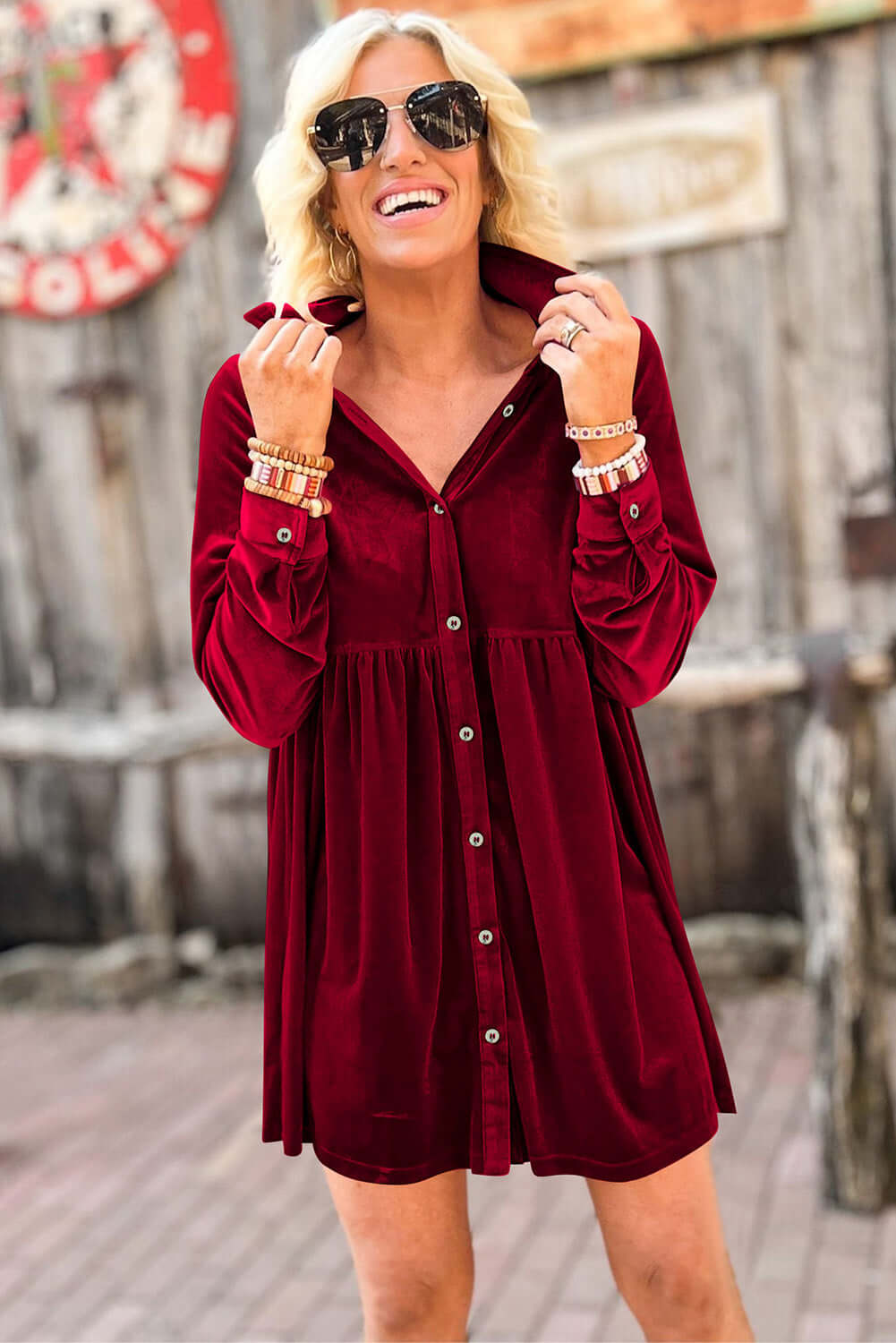 Woman wearing Vivian-Lu berry velvet dress with buttons and collared neck, showcasing style and comfort with a vibrant look.