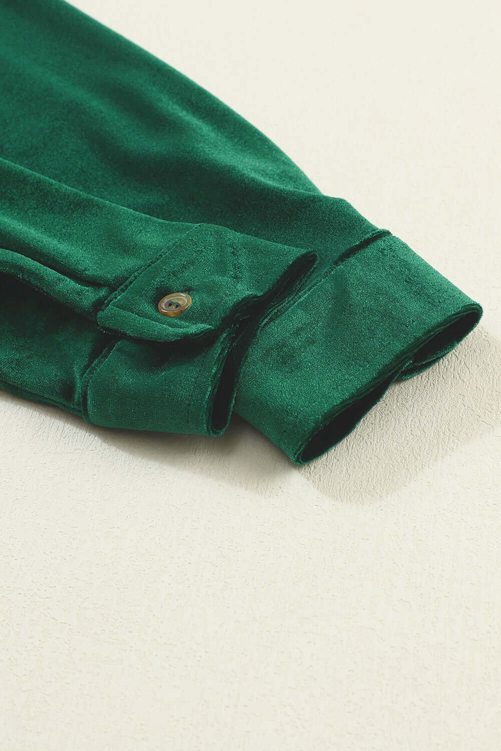 Evergreen velvet dress sleeve detail by Vivian-Lu showing button cuff and crinkled fabric texture.