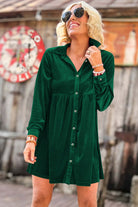 Woman wearing evergreen vibrant velvet dress with crinkled texture and collar neck, outdoors setting.