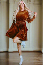 "Model wearing CHESTNUT CHEER Dress by Vivian-Lu in chestnut brown velvet with long gigot sleeves and gathered waist"