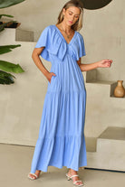 Model wearing Sky Blue Dreamfield Days Maxi Dress with flutter sleeves in a stylish indoor setting.