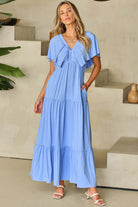 Model in a sky blue Dreamfield Days maxi dress with flutter sleeves, showcasing summer elegance and comfort.