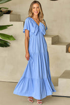 Model in a serene sky blue maxi dress with flutter sleeves, perfect for summer brunches and garden walks.
