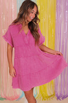 Model in a strawberry pink tiered dress with split neckline, showcasing effortless summer style.