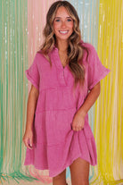 Model in a strawberry pink mineral wash dress with a split neckline and tiered silhouette.