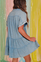 Sky blue mineral wash dress with tiered silhouette and relaxed fit, showcased against colorful backdrop.