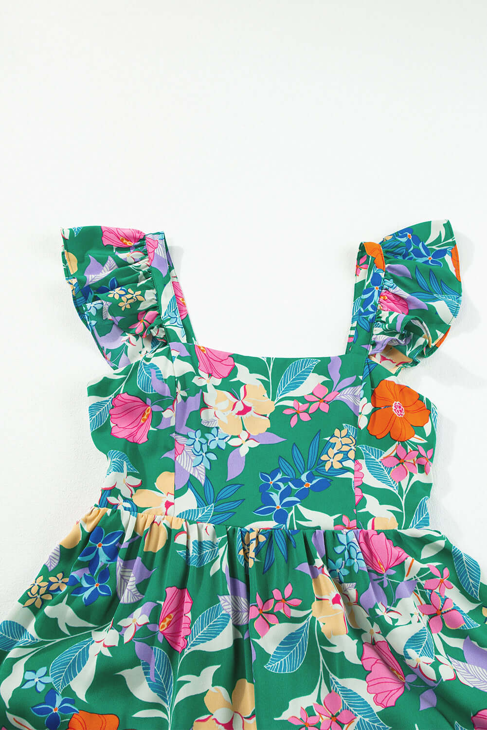 Vibrant green floral dress with ruffled straps and colorful floral pattern for summer occasions.