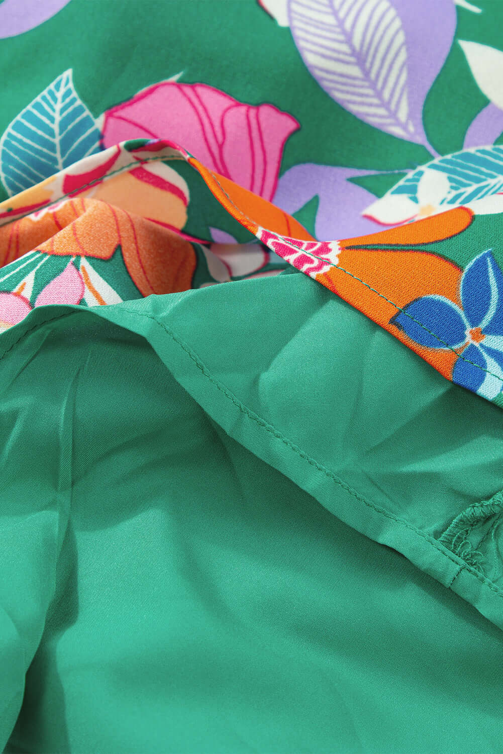 Close-up of vibrant floral fabric featuring pink and green colors for the Summer Symphony Dress.