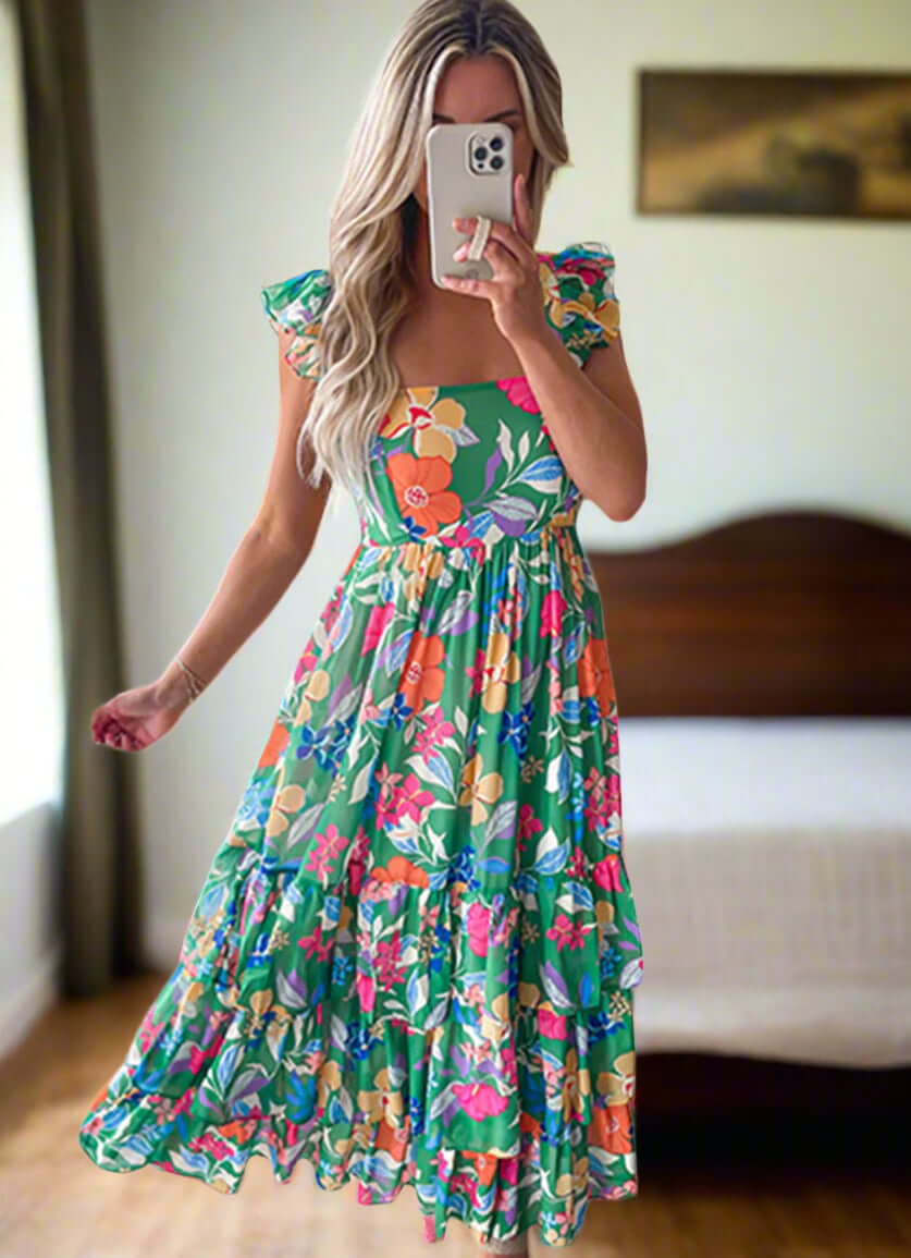 Model in a vibrant floral maxi dress with ruffled straps, perfect for summer outings and twirling in style.