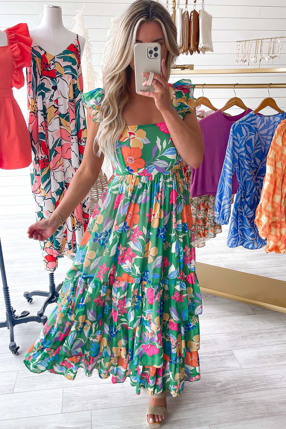 Model wearing the Summer Symphony Dress, a green floral maxi with ruffled straps and tiered design, perfect for sunny days.