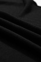 Close-up of soft black fabric pleats featuring a lightweight, high-stretch knit texture.