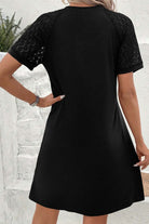 Chic black shift dress with lace sleeves, pleated neckline, and relaxed fit for stylish comfort.