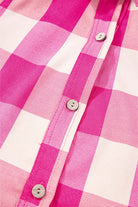 Close-up of pink and white checkered fabric with buttons, perfect for the trendy Check Her Out Dress.