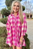 Model wearing a stylish Check Her Out Dress in pink checkered pattern, featuring a collared neck and bracelet sleeves.