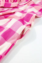 Close-up of the stylish Check Her Out Dress in pink and white check pattern, showcasing the collar and sleeve details.