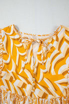 Close-up of Golden Maize dress highlighting chic bohemian print and tied V-neckline detail with playful puff sleeves.