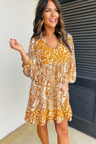 Woman wearing Golden Maize Dress with bohemian print, puff sleeves, and tied V-neckline for a chic, feminine style.