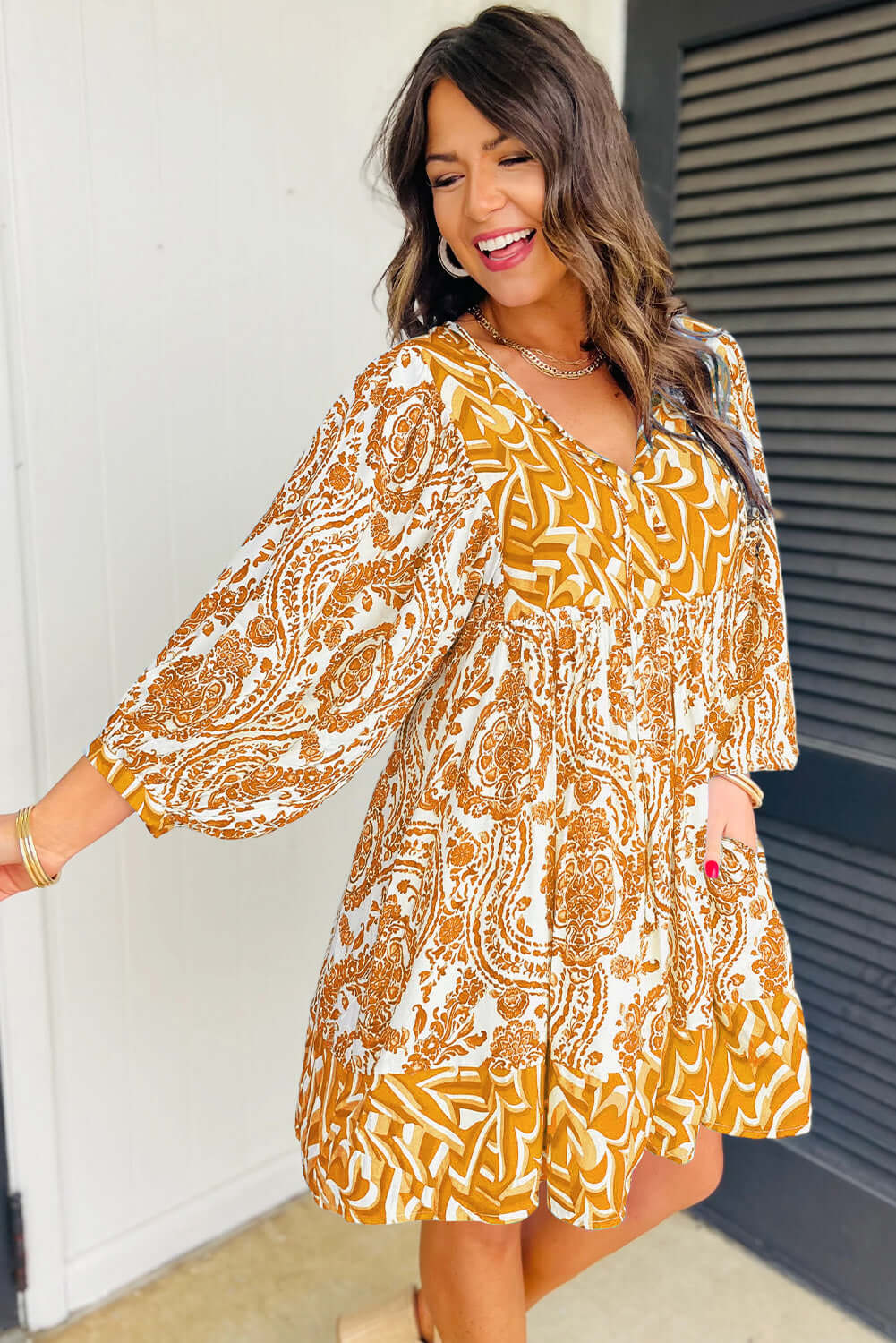 Woman in bohemian Golden Maize dress with puff sleeves and V-neckline, showcasing chic print and flattering fit-and-flare design.