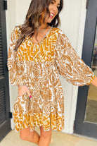 Woman wearing bohemian Golden Maize dress with puff sleeves and tie V-neckline.