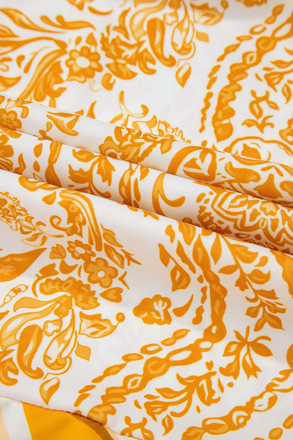 Vibrant golden print fabric close-up of Vivian-Lu's Golden Maize Dress, showcasing intricate bohemian floral patterns on polyester.