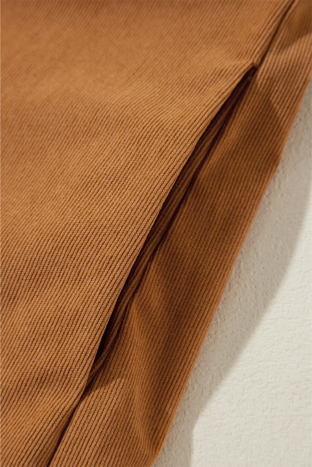 Copper corduroy fabric with delicate pleating detail from DESERT WINDS Dress, showcasing texture and luxury.